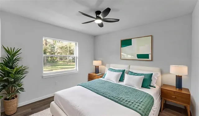 a bedroom with a large bed and a potted plant