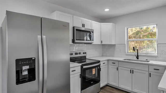 a kitchen with a sink stove and microwave