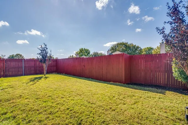 a view of a backyard with wooden fence