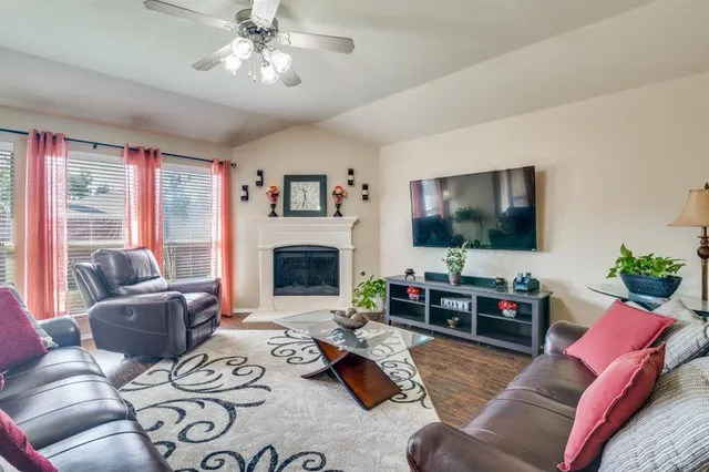 a living room with furniture a flat screen tv and a fireplace