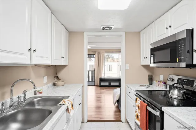 a kitchen with granite countertop a sink a stove and cabinets