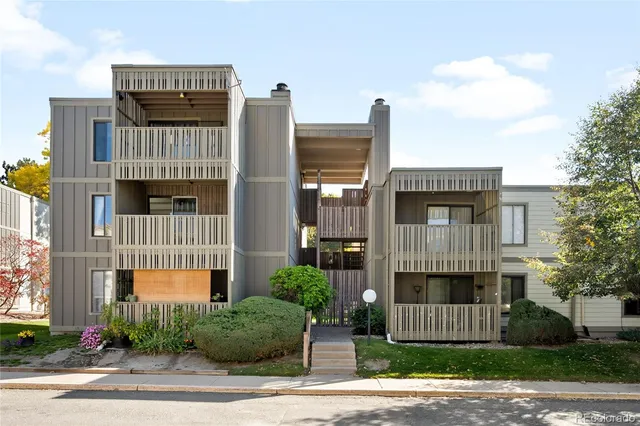 a front view of a building with a garden and plants