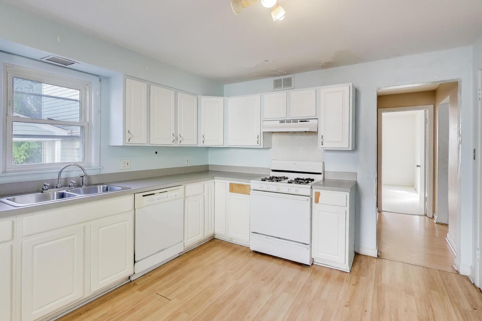 221 Heine Avenue Elgin, IL 60123 - Photo 11 of 43 a kitchen with a sink a stove and cabinets