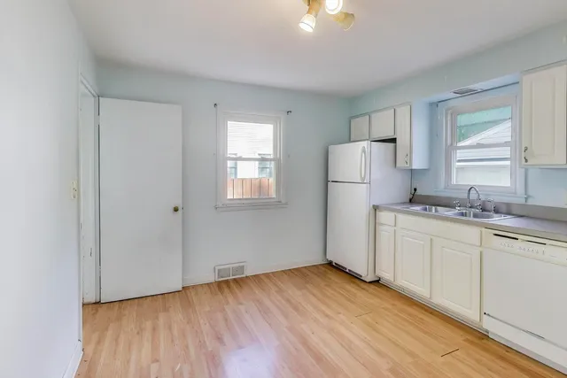 an empty room with a ceiling fan and window