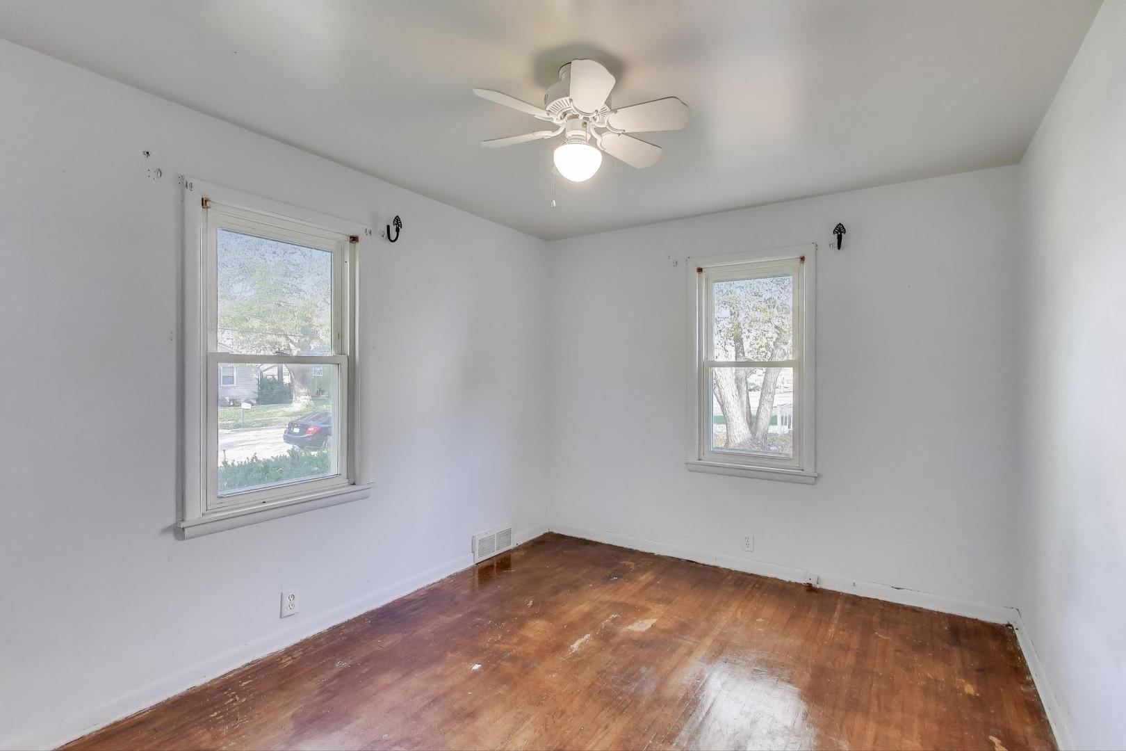 221 Heine Avenue Elgin, IL 60123 - Photo 16 of 43 a view of an empty room with a window and wooden floor
