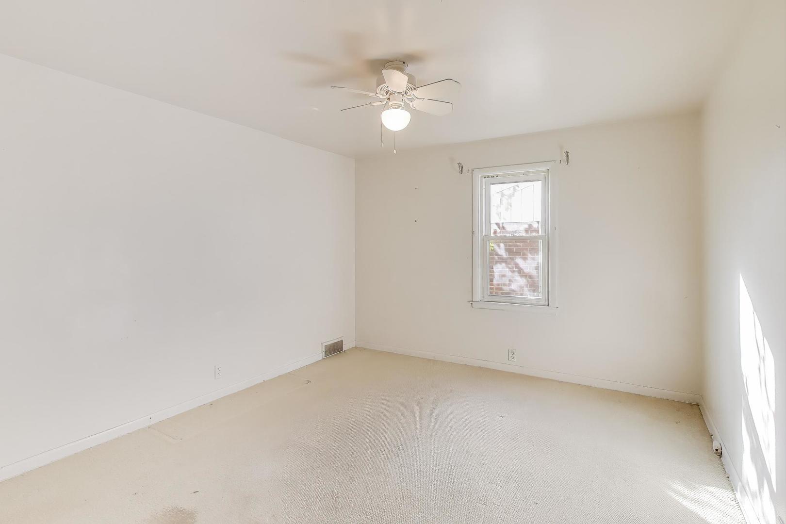 221 Heine Avenue Elgin, IL 60123 - Photo 18 of 43 an empty room with a ceiling fan and window