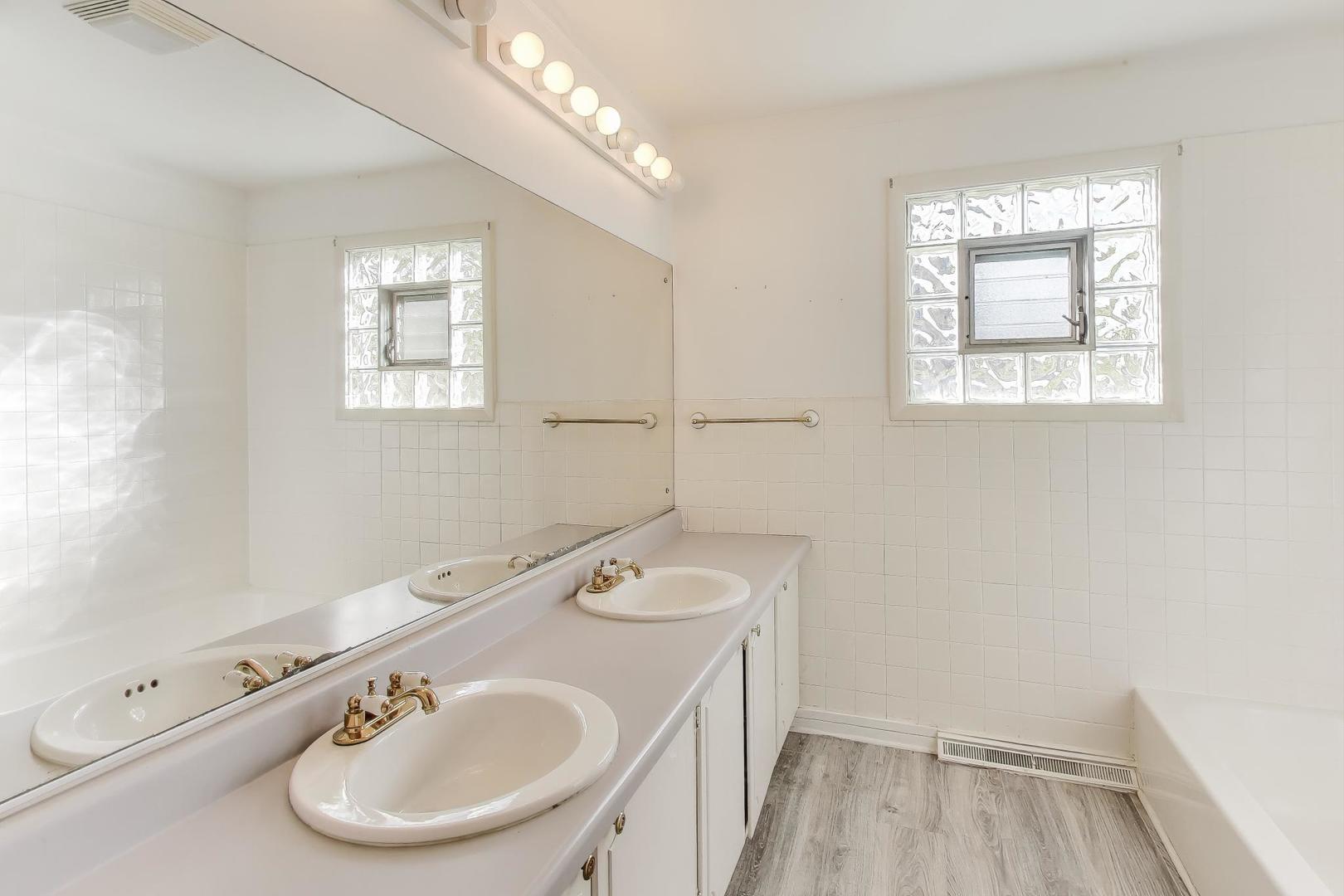 221 Heine Avenue Elgin, IL 60123 - Photo 25 of 43 a bathroom with a sink a toilet and a window