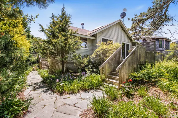 a front view of a house with a yard and potted plants
