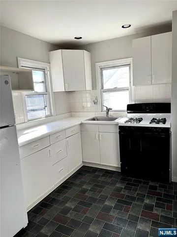 a kitchen with a sink stove top oven and cabinets