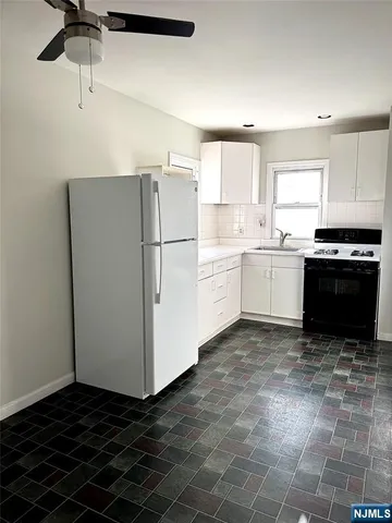 a kitchen with a refrigerator and a stove top oven