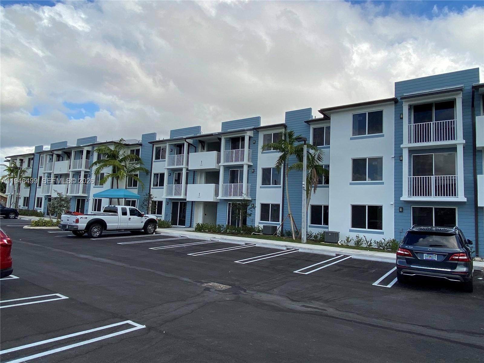 26511 Southwest 146th Court, Unit 216 Homestead, FL 33032 - Photo 1 of 6 a car parked in front of a building