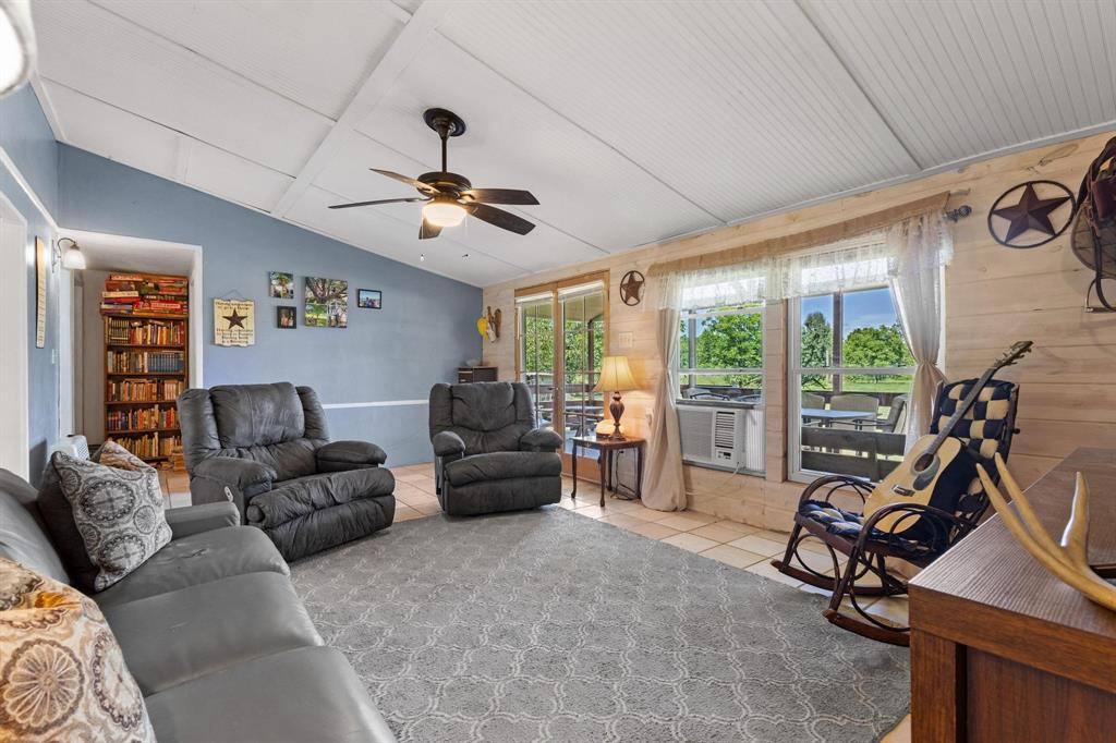 489 Delphia Drive Denison, TX 75021 - Photo 11 of 40 a living room with furniture a floor to ceiling window and a flat screen tv