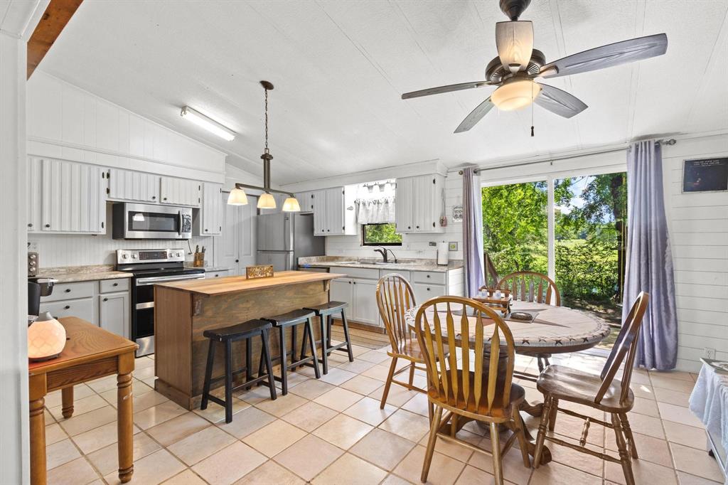 489 Delphia Drive Denison, TX 75021 - Photo 13 of 40 a kitchen with stainless steel appliances granite countertop a stove top oven a sink dishwasher a dining table and chairs with wooden floor