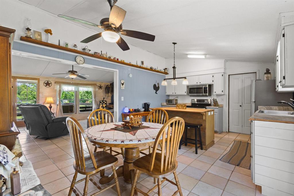 489 Delphia Drive Denison, TX 75021 - Photo 15 of 40 a dining room with furniture a large window and stainless steel appliances