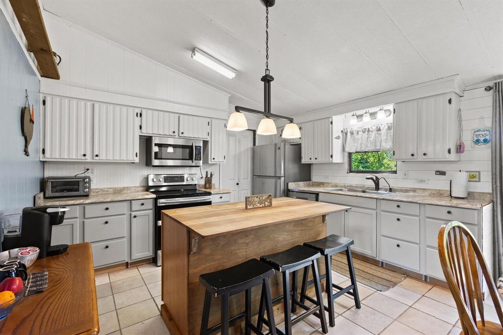 489 Delphia Drive Denison, TX 75021 - Photo 16 of 40 a kitchen with stainless steel appliances granite countertop a stove top oven a sink a stove a dining table and chairs
