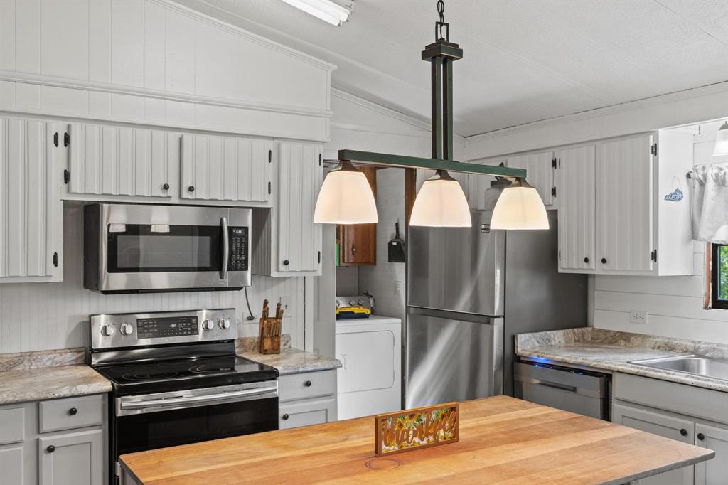 489 Delphia Drive Denison, TX 75021 - Photo 19 of 40 a kitchen with stainless steel appliances granite countertop a refrigerator stove and microwave