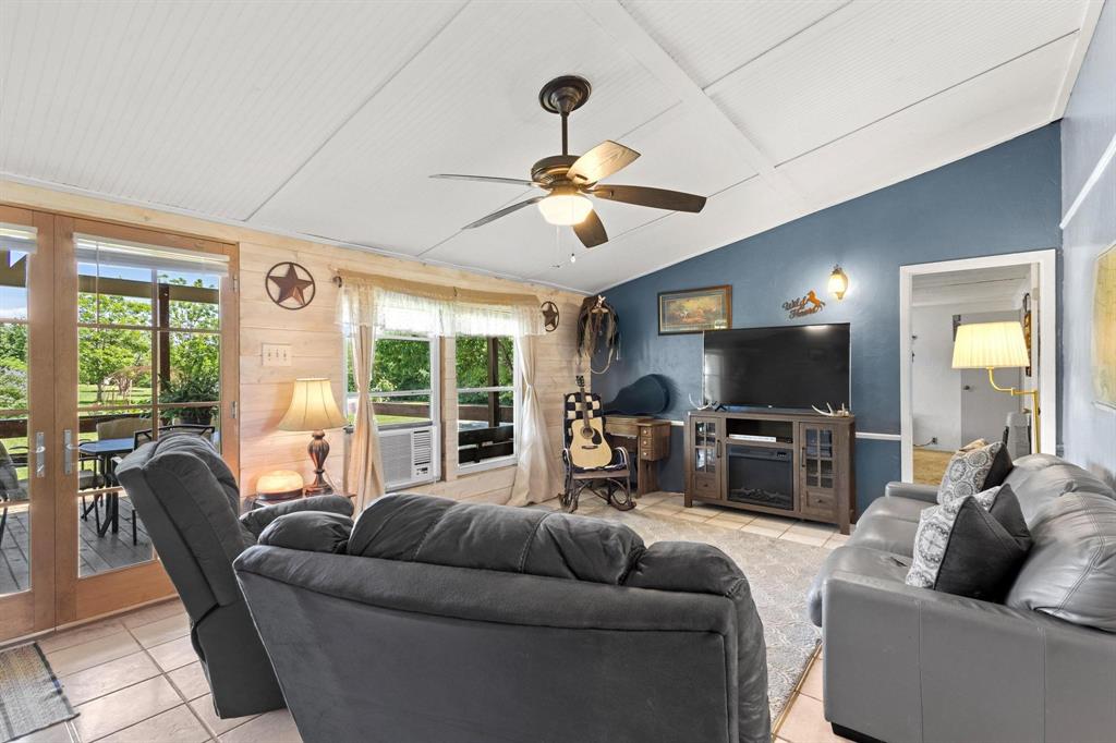 489 Delphia Drive Denison, TX 75021 - Photo 10 of 40 a living room with furniture a flat screen tv and a large window