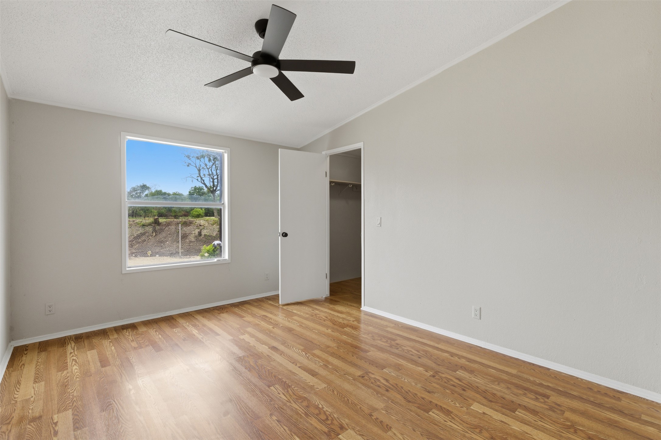 376 Rae Lane, Unit A Jarrell, TX 76537 - Photo 16 of 31 Room featuring wood-finish flooring, a contemporary ceiling fan, and a wide window