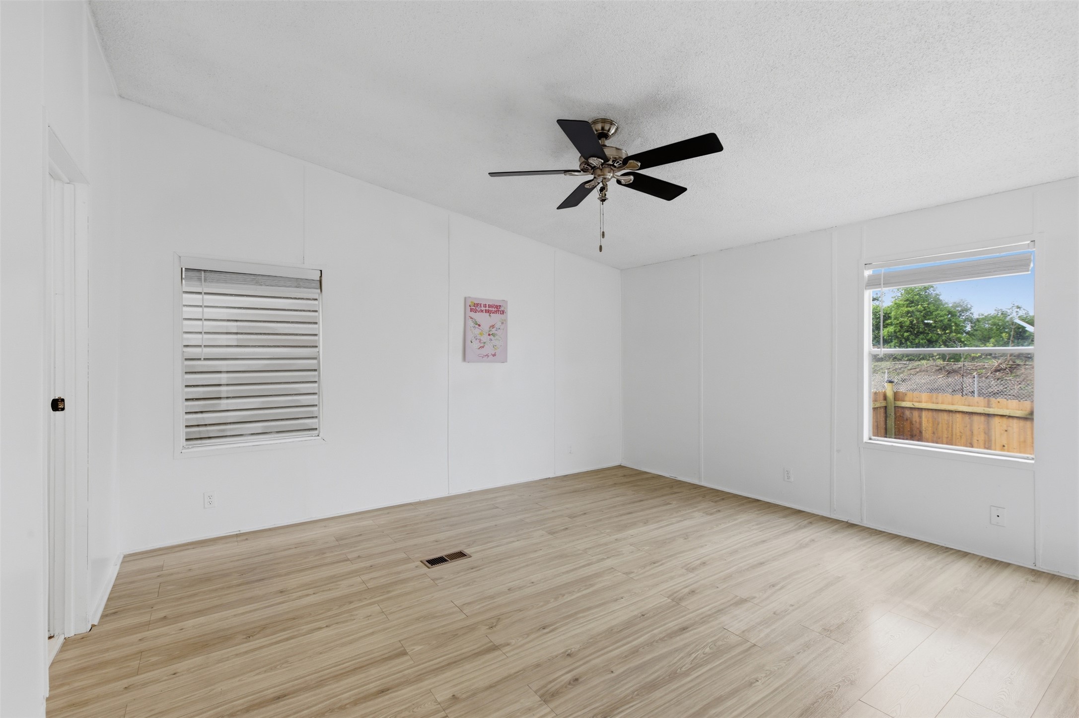 376 Rae Lane, Unit A Jarrell, TX 76537 - Photo 22 of 31 Open-concept room featuring light wood-finish flooring, white walls, and a ceiling fan with integrated lighting