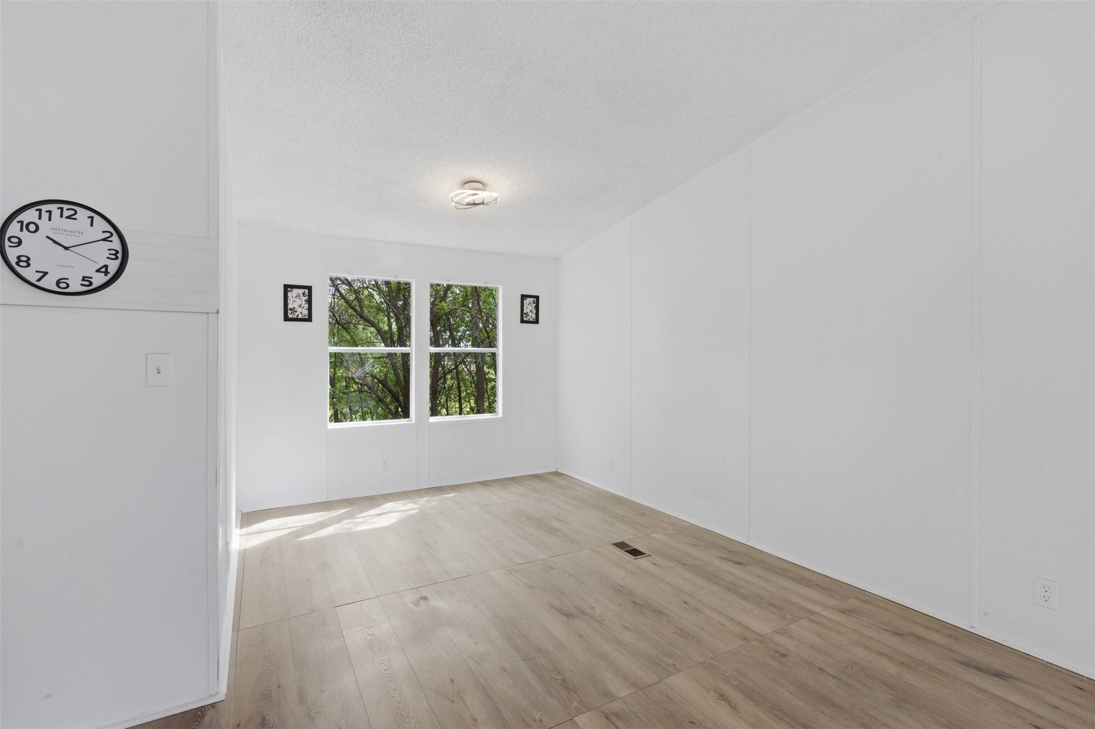 376 Rae Lane, Unit A Jarrell, TX 76537 - Photo 25 of 31 Bright interior space featuring wood-finish flooring, white walls, and a pair of windows providing natural light