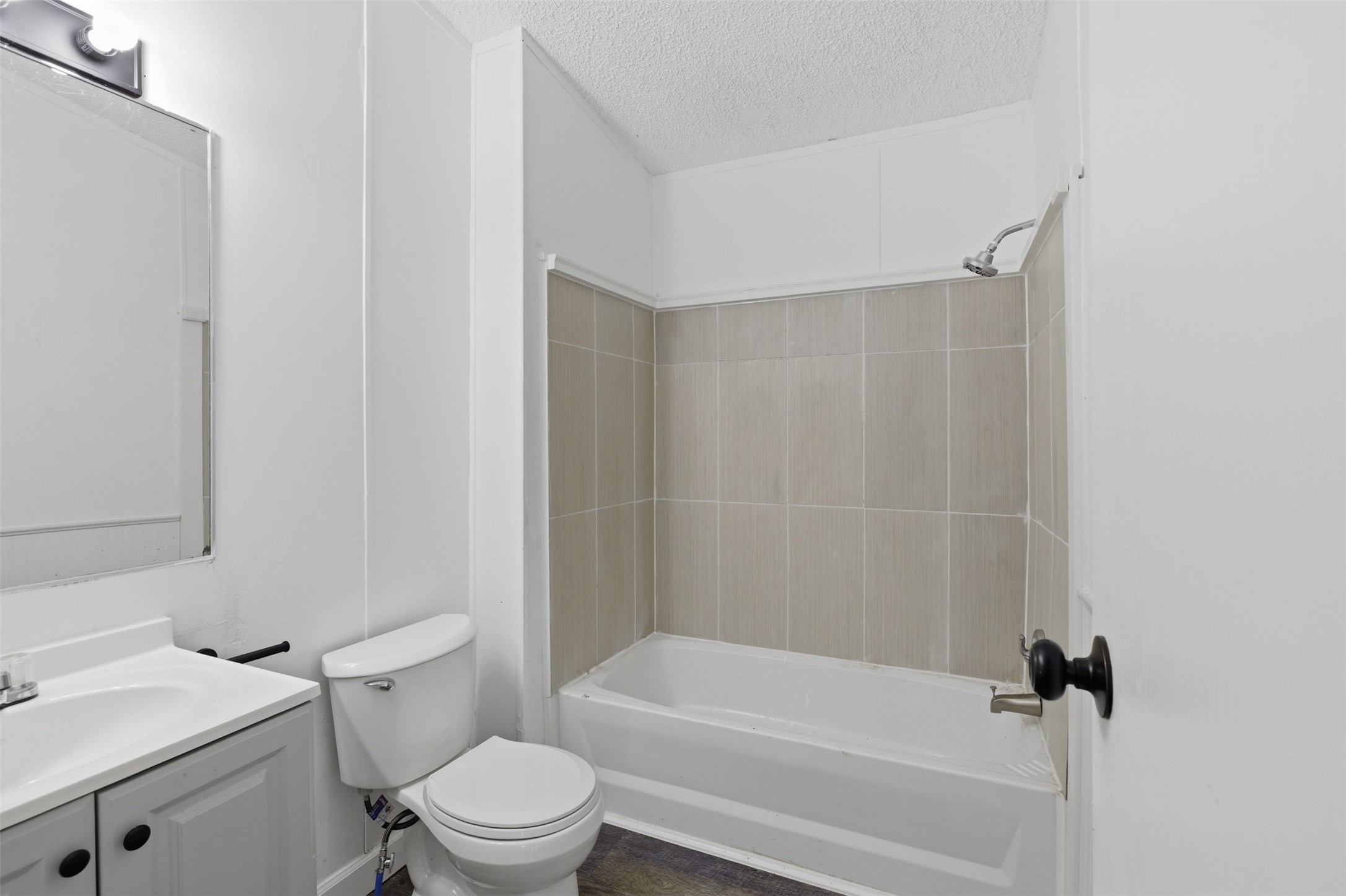 376 Rae Lane, Unit A Jarrell, TX 76537 - Photo 28 of 31 Full bathroom featuring a single vanity with under-sink cabinetry, a standard toilet, and a combination tub and shower with light-toned tile surround