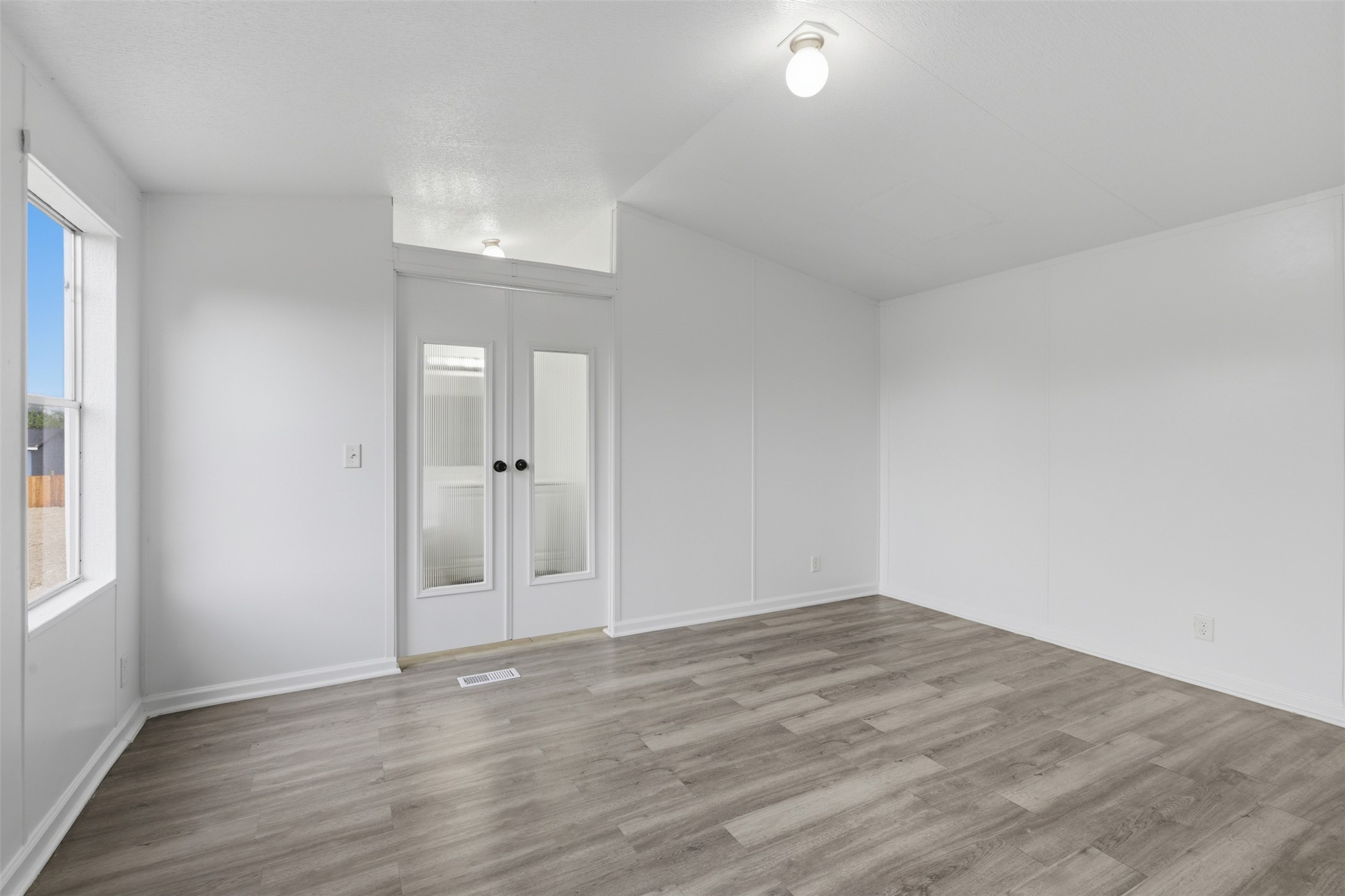 376 Rae Lane, Unit A Jarrell, TX 76537 - Photo 6 of 31 Spacious interior room featuring wood-finish flooring, white baseboards, and a neutral wall palette