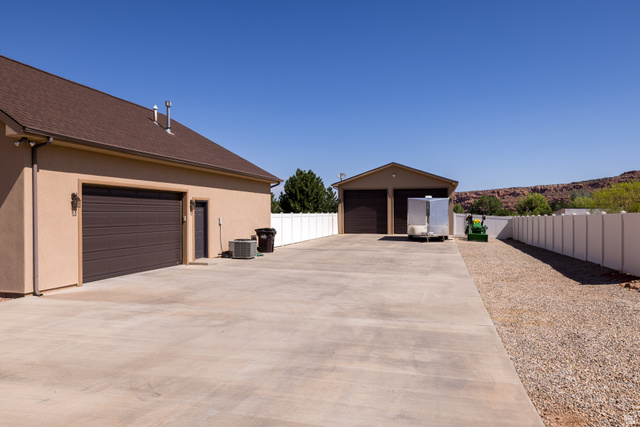 4635 East Sunny Acres Lane Moab, UT 84532 - Photo 18 of 56 Expansive concrete driveway leading to a two-car garage and a detached two-door garage structure