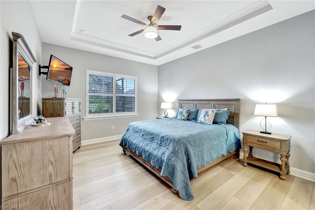 7451 Blackberry Drive Naples, FL 34114 - Photo 15 of 30 a bedroom with a bed and a chandelier