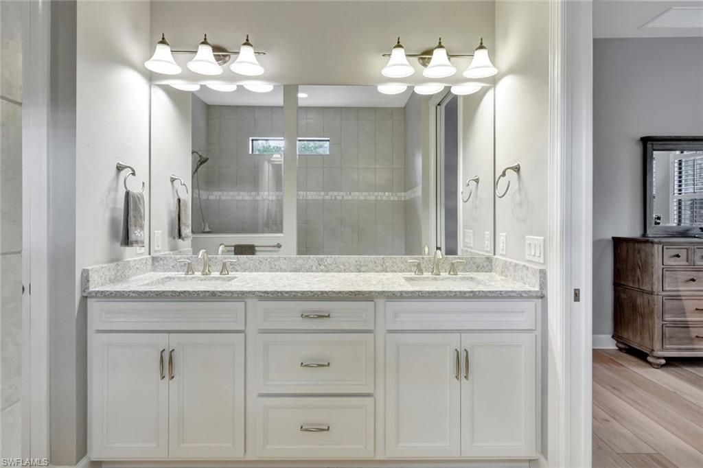 7451 Blackberry Drive Naples, FL 34114 - Photo 17 of 30 a bathroom with a granite countertop double vanity sink and a mirror