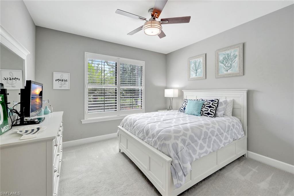 7451 Blackberry Drive Naples, FL 34114 - Photo 20 of 30 a bedroom with a bed flat screen tv and a window