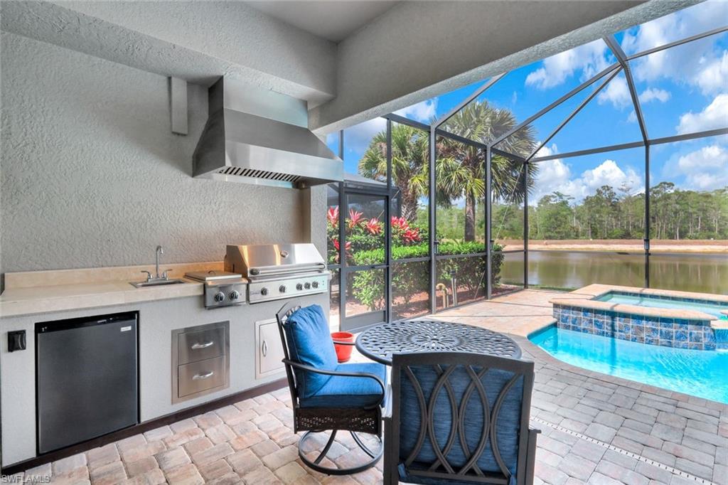 7451 Blackberry Drive Naples, FL 34114 - Photo 27 of 30 a kitchen with a stove a refrigerator and wooden floor