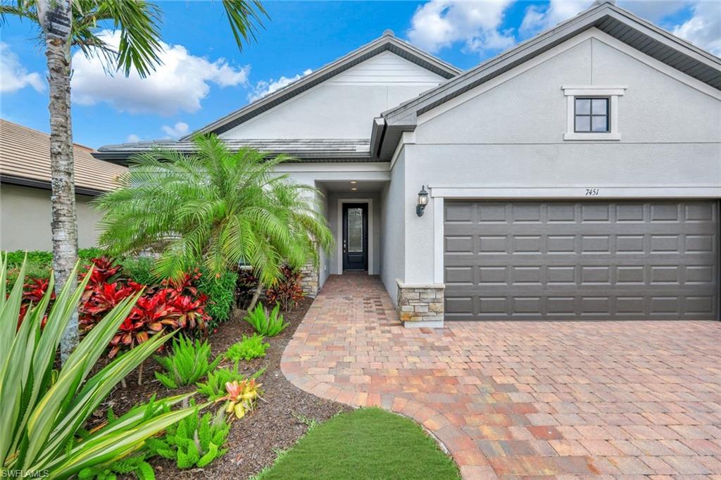 7451 Blackberry Drive Naples, FL 34114 - Photo 3 of 30 a front view of a house with a yard and potted plants