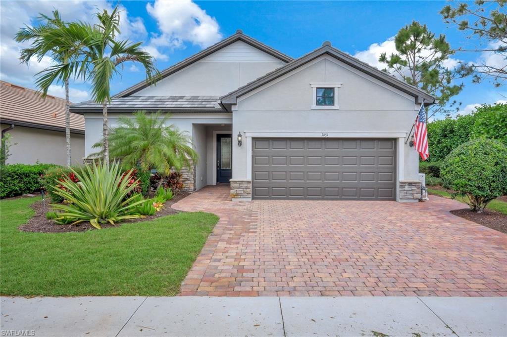7451 Blackberry Drive Naples, FL 34114 - Photo 4 of 30 a front view of a house with a yard and garage