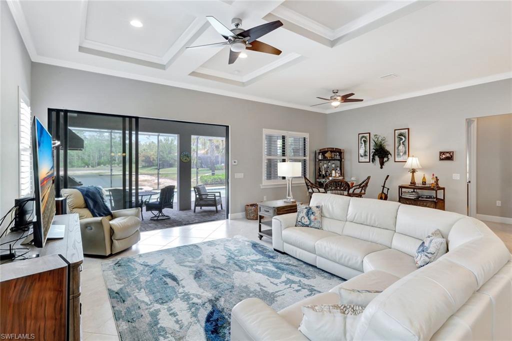 7451 Blackberry Drive Naples, FL 34114 - Photo 6 of 30 a living room with furniture ceiling fan and a large window