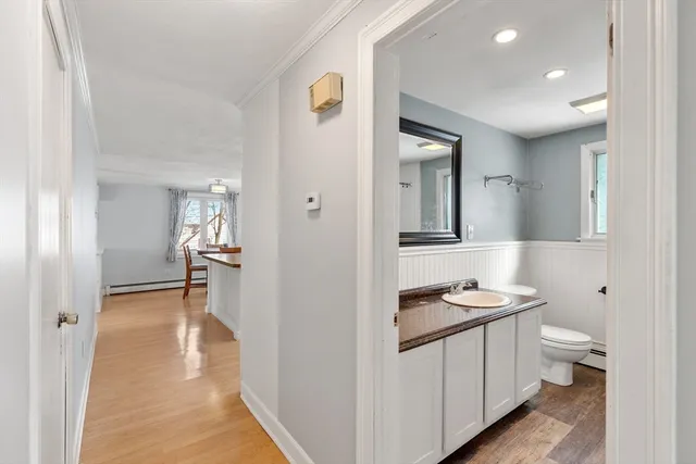 a hallway with white cabinets and wooden floor