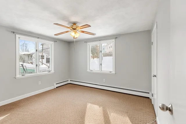 an empty room with windows and fan