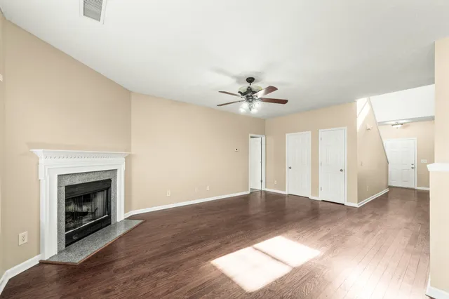 an empty room with windows and fireplace