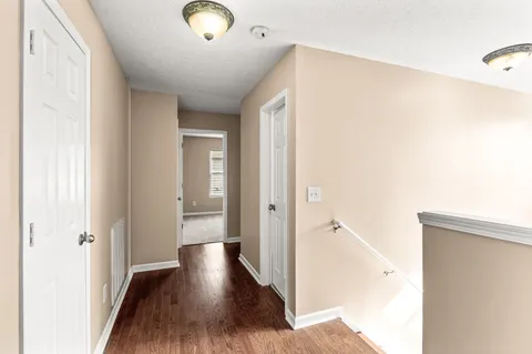 a view of an empty room and chandelier fan