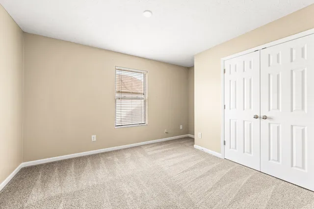 en empty room with ceiling fan and window
