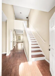 a view of a big room with wooden floor and windows