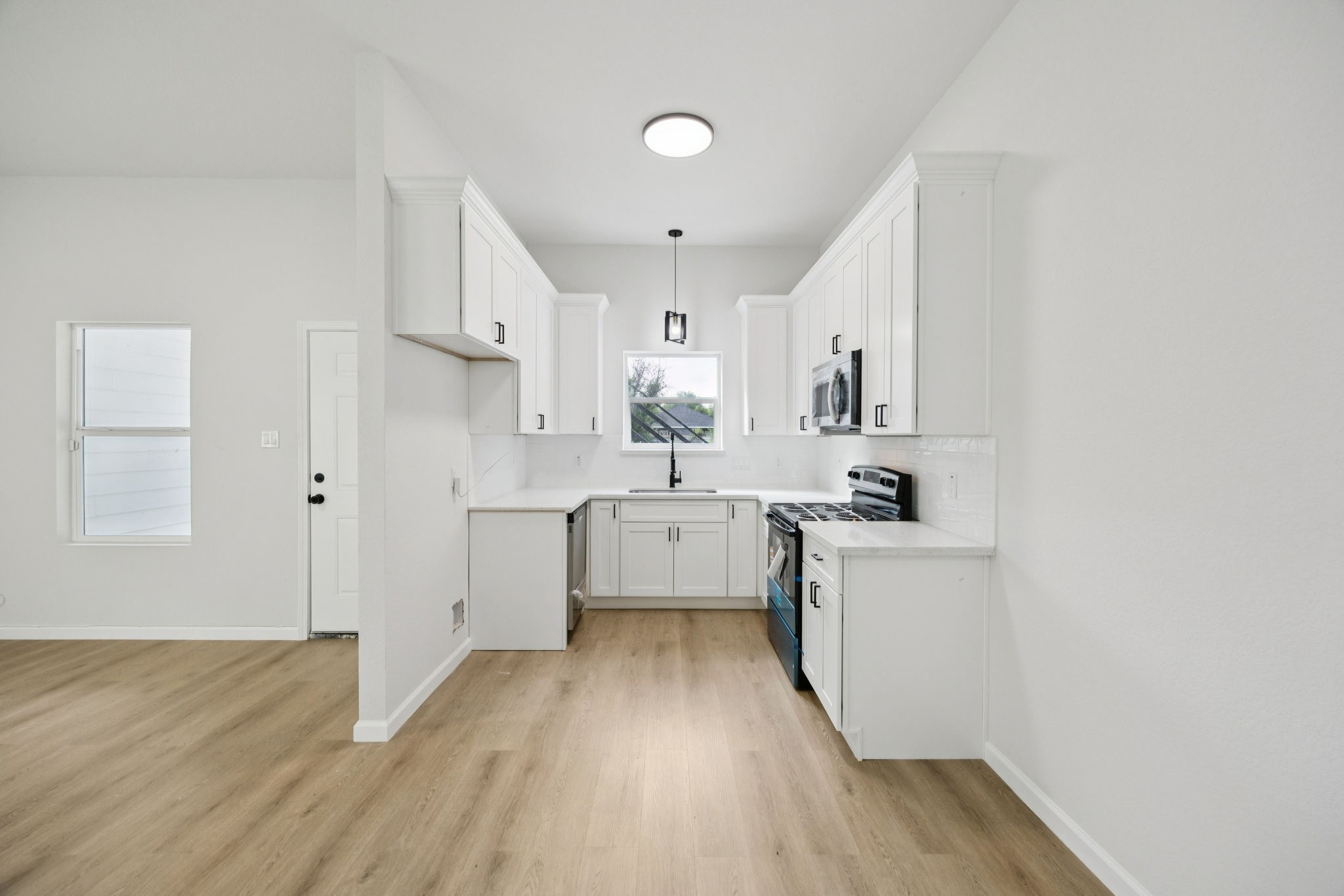 301 Cartersville Street, Unit B Houston, TX 77029 - Photo 1 of 23 a kitchen with white cabinets and wooden floor