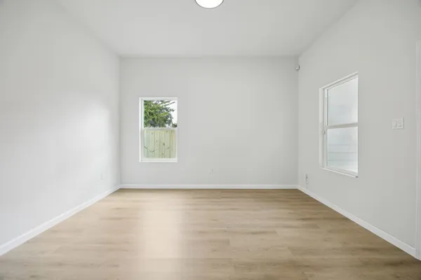 an empty room with wooden floor and window