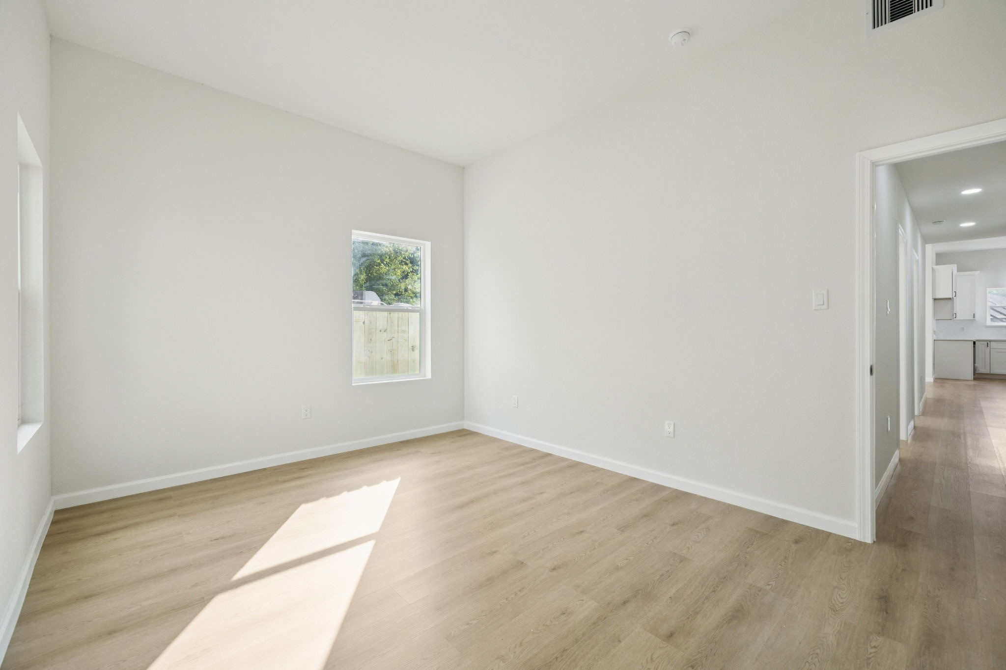 301 Cartersville Street, Unit B Houston, TX 77029 - Photo 15 of 23 an empty room with wooden floor and windows