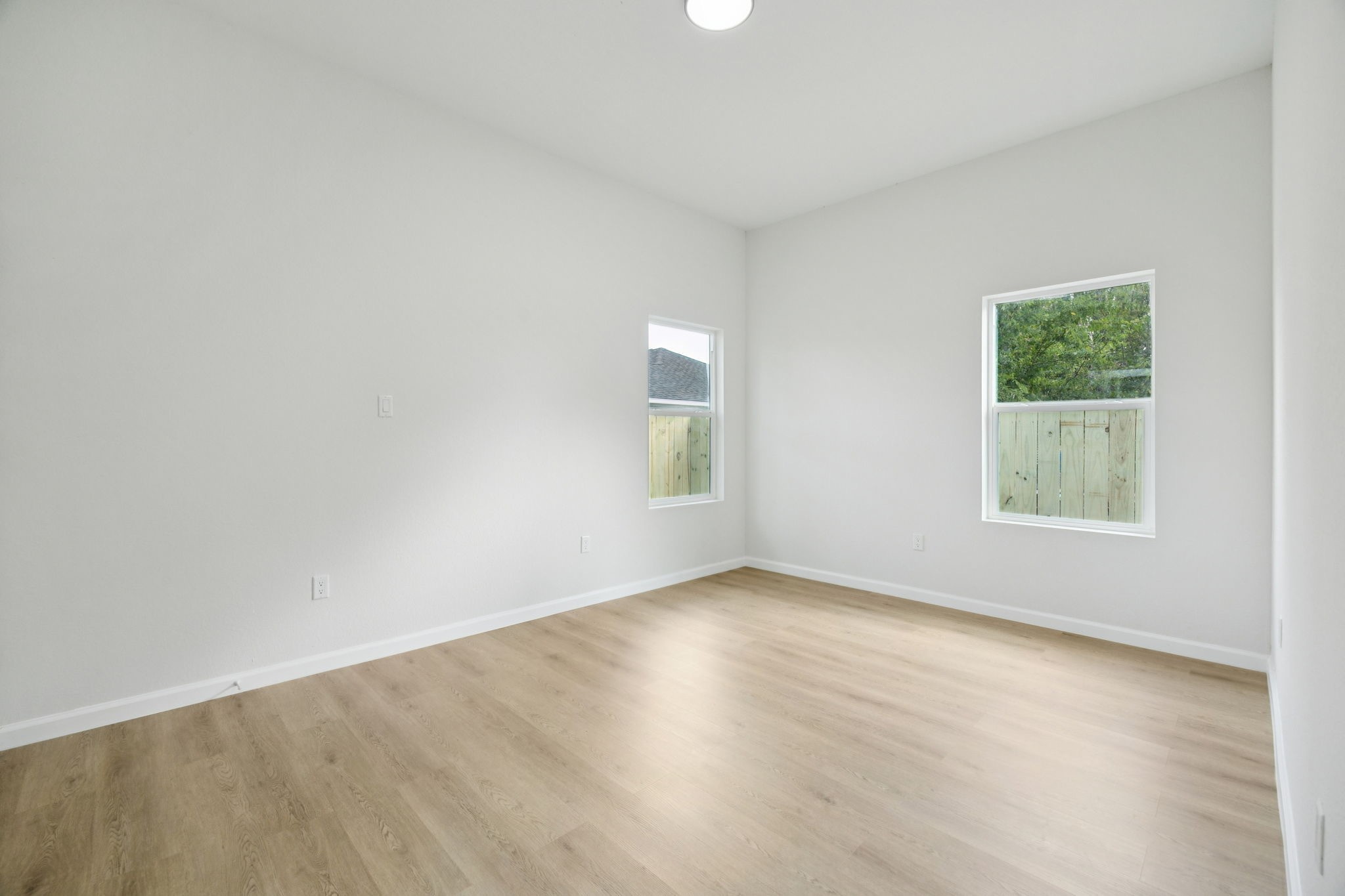 301 Cartersville Street, Unit B Houston, TX 77029 - Photo 19 of 23 an empty room with wooden floor and windows