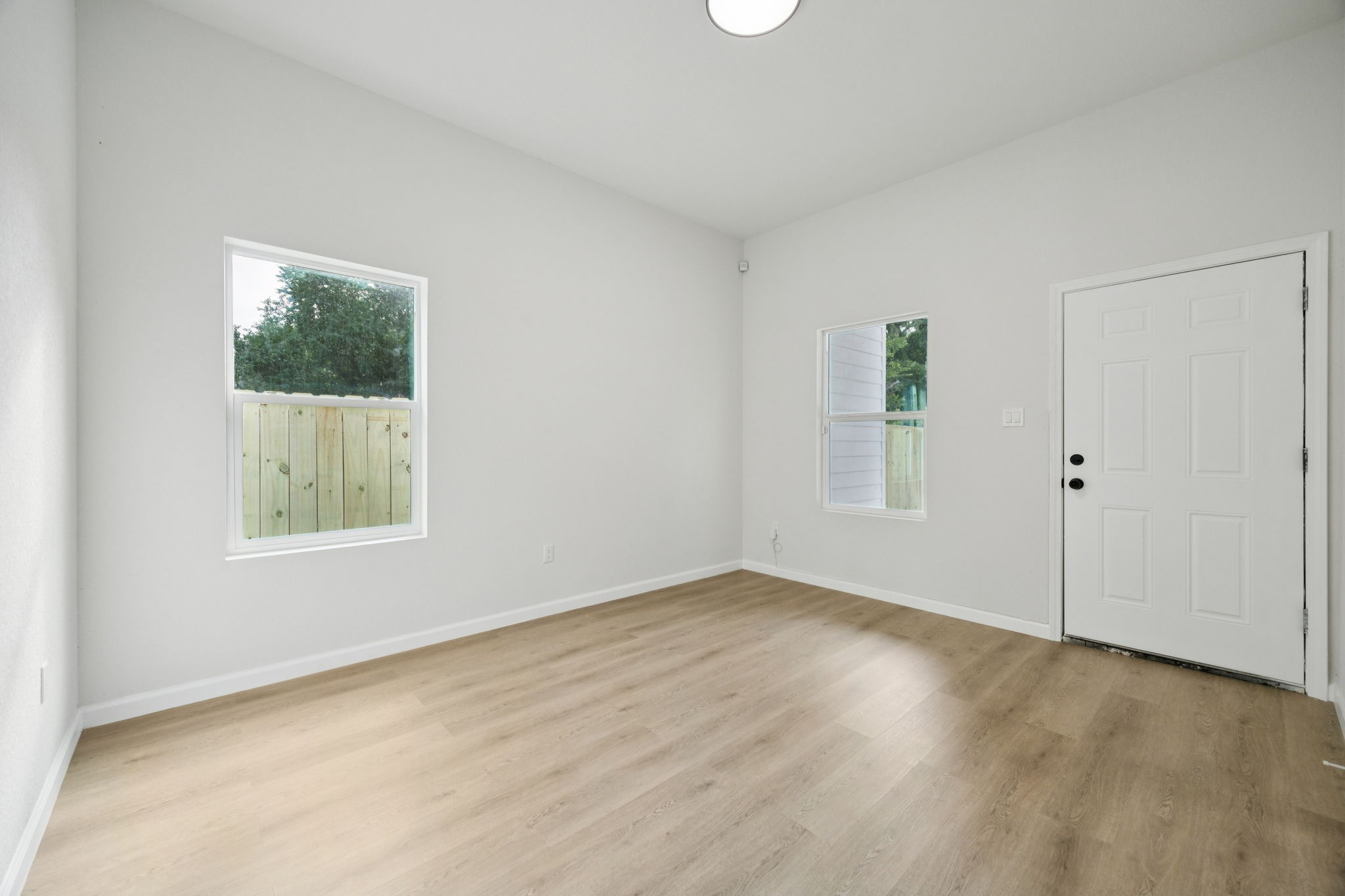 301 Cartersville Street, Unit B Houston, TX 77029 - Photo 22 of 23 an empty room with wooden floor and windows