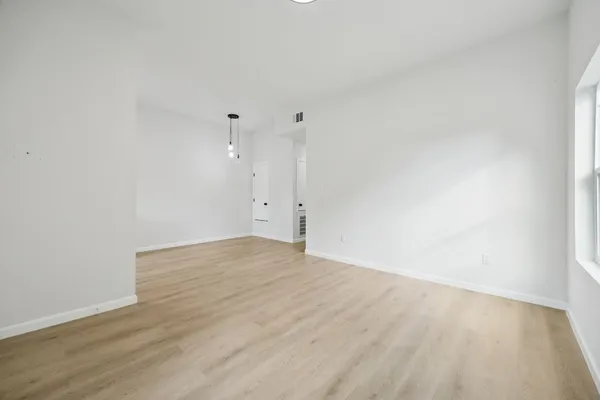 a view of empty room with wooden floor