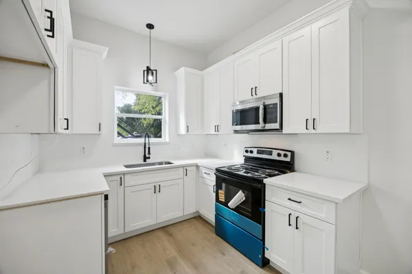 a kitchen with a sink stove and microwave
