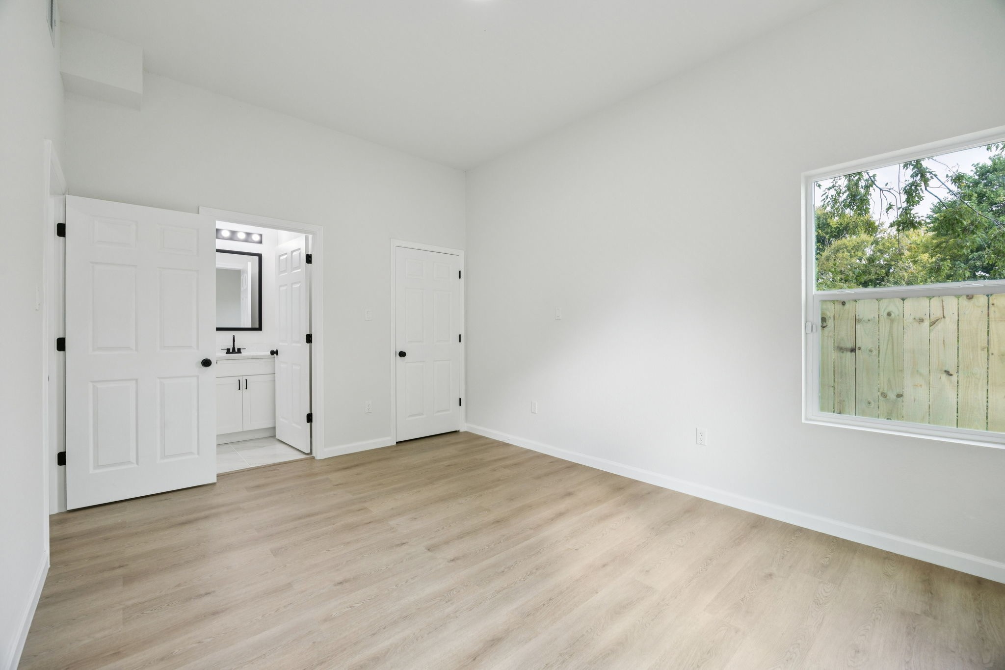 301 Cartersville Street, Unit B Houston, TX 77029 - Photo 7 of 23 an empty room with a window and wooden floor