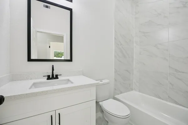 a bathroom with a toilet a sink and mirror