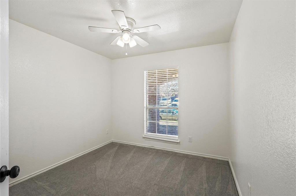 5169 East Rim Road Dallas, TX 75211 - Photo 16 of 19 Room featuring light grey carpet flooring, white walls, and a ceiling fan with integrated lighting